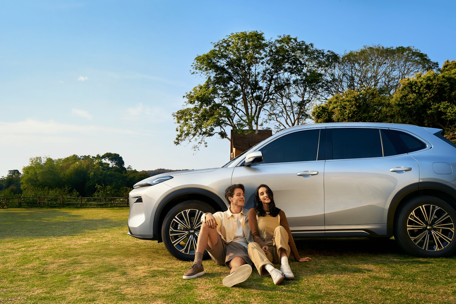 Pasangan bersantai di samping Geely EX5